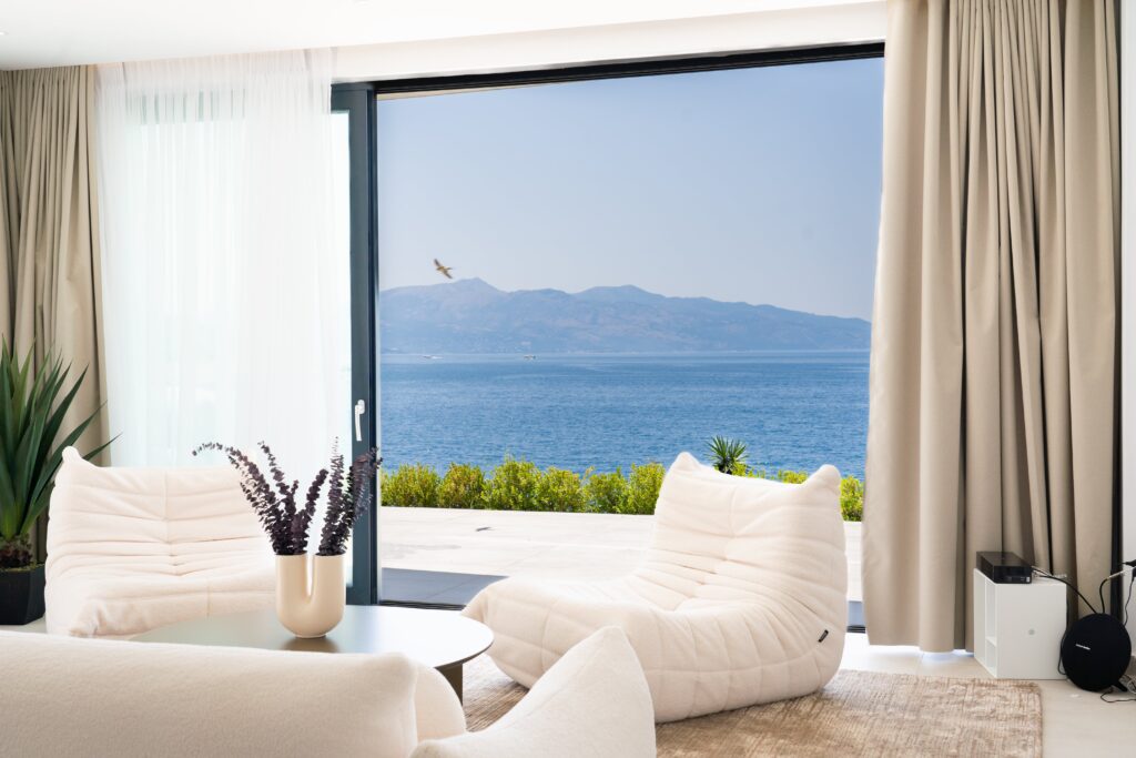 sea views of corfu from the minimalistic design interior of white sofas and brown curtains at palmera resort in saranda