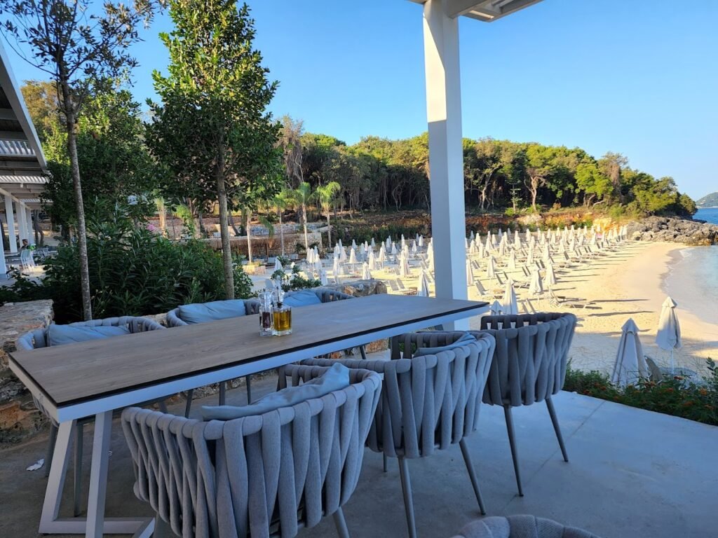 Arameras Beach, secluded beach in Ksamil, Albania with white sunbeds , restaurant and corfu views