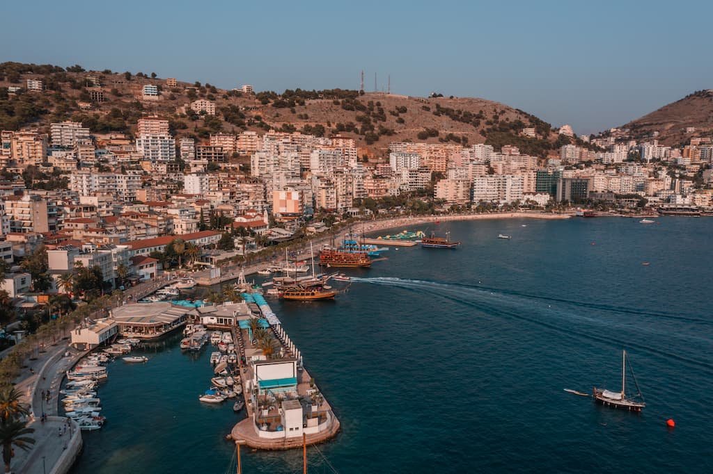 Bird's eye view of Saranda's stunning waterfront promenade, with restaurants, shops, and palm trees 