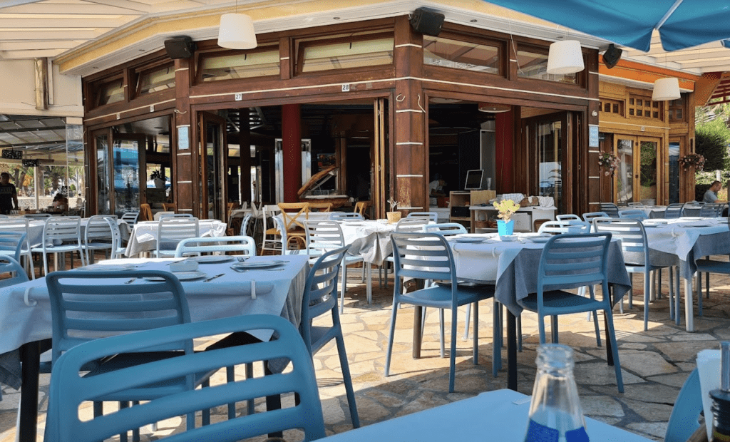 Limani Restaurant in Saranda, Albania, dining area with tables and chairs, elegant decor, and panoramic sea views