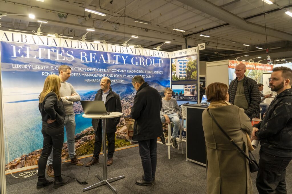 Photo of people interacting at a real estate expo, with industry professionals and potential buyers networking and discussing property investments