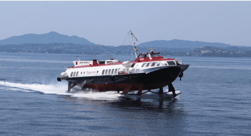 View of a ferry boat in Saranda, with clear blue water and mountains in the background