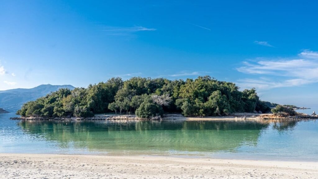 Ksamil Islands Beach showing the sandy landscape and one of the island lush greenes and forest