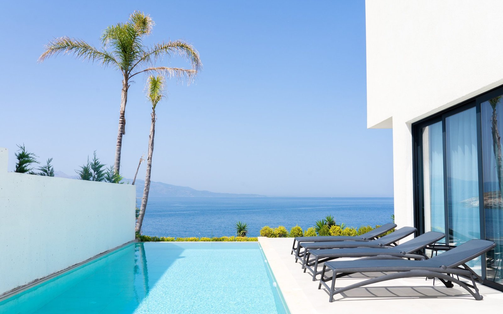 villa with sea views in the ionian sea looking the corfu island from the swimming pool and palms at palmera resort albania