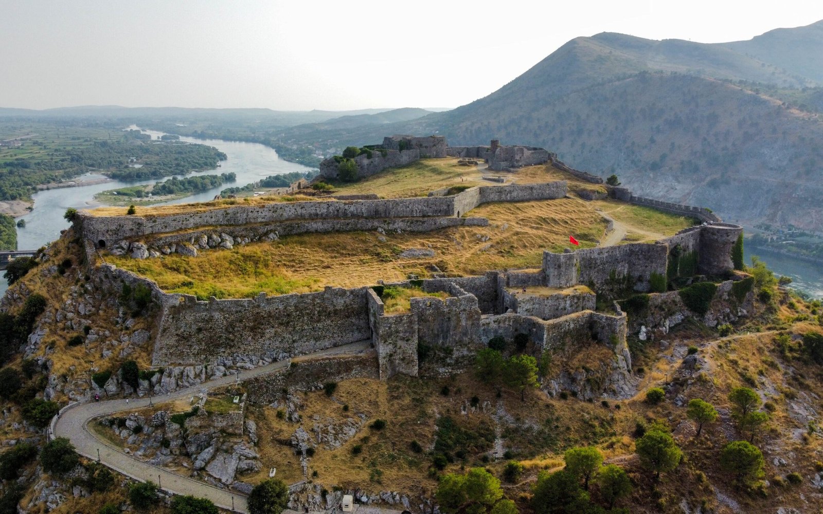 gjirokaster castle architexture in albania with mountain views, greneery and river